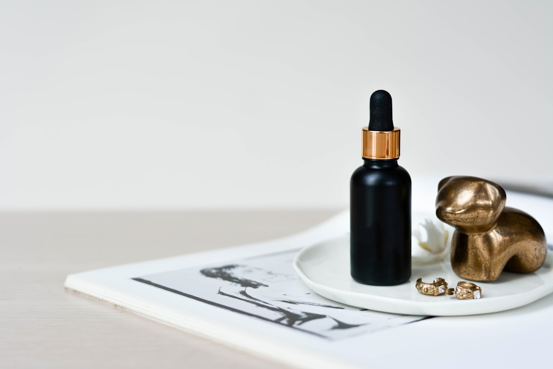 A black dropper bottle with gold details.