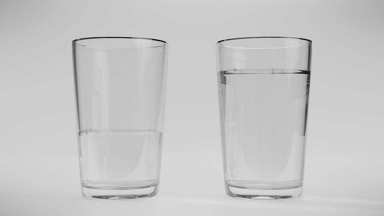 Two clear glasses of water on a neutral background symbolizing hydration balance and moisture care in dry climates.