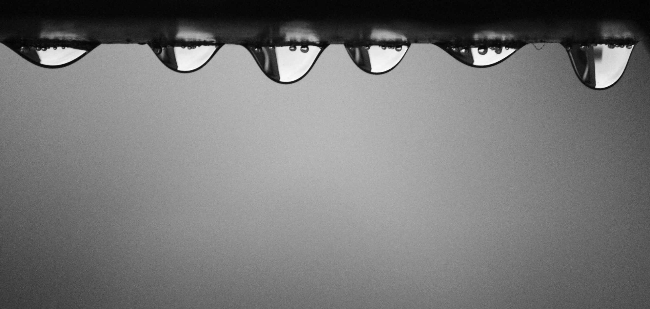 A close-up macro image of water droplets on a smooth surface, symbolizing hydration and skin barrier repair in a dry climate.