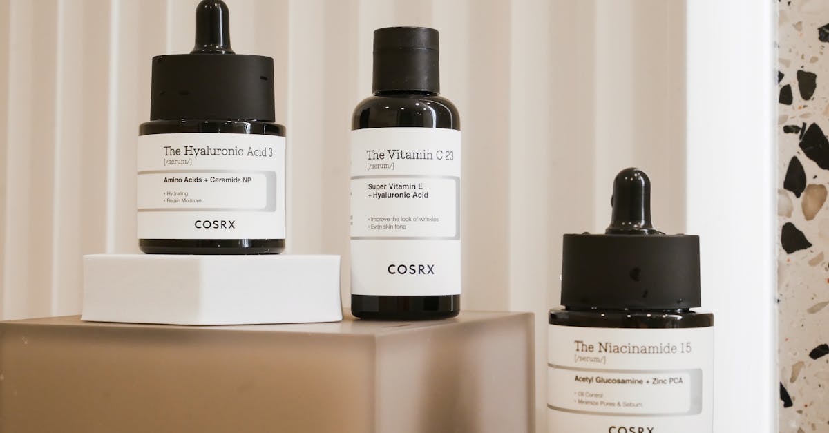 COSRX hydrating serums including hyaluronic acid, vitamin C, and niacinamide displayed on blocks; Korean skincare products for dry skin and barrier care