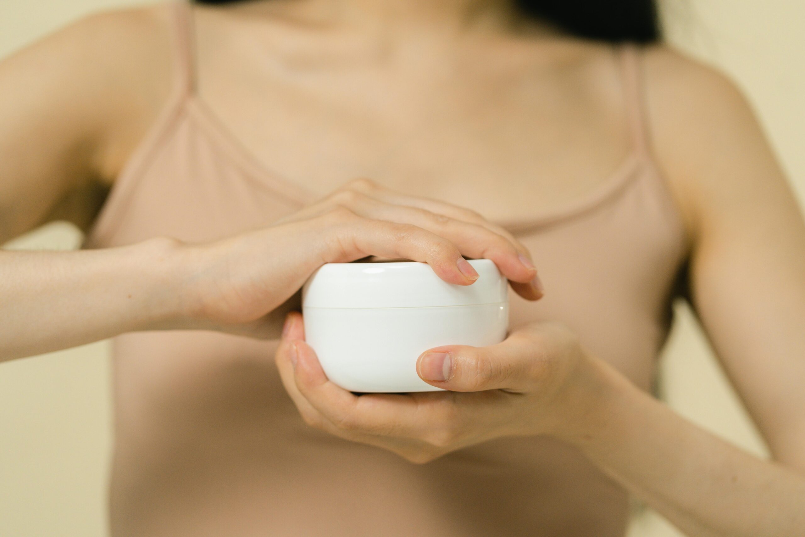 Person holding moisturizer cream for extremely dry winter skin in a cold, low-humidity climate