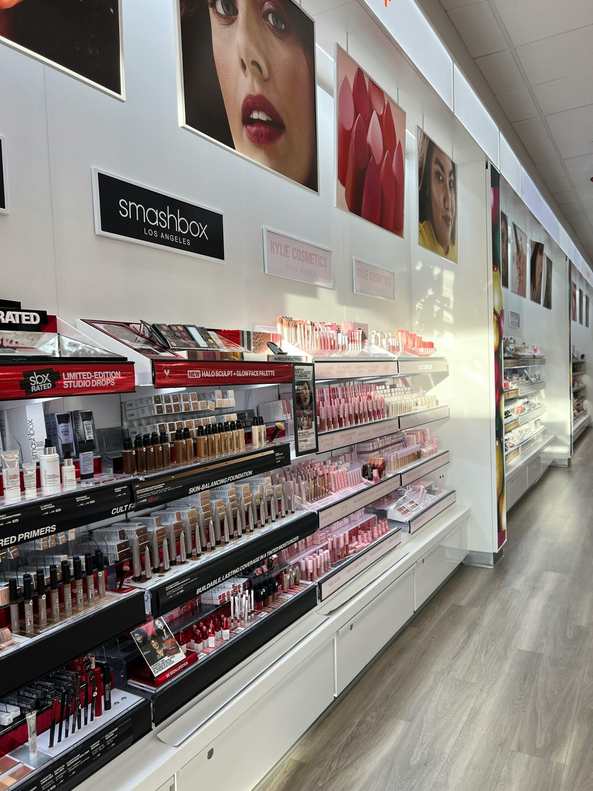 A cosmetic store aisle filled with a variety of makeup products under bright lighting.